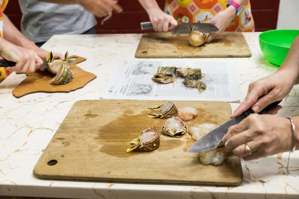 Hands chopping the raw lobster, still in its shell