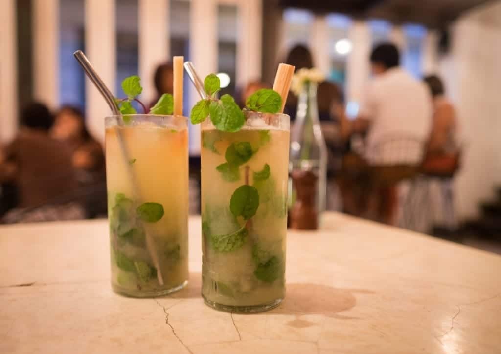 A tourist enjoying a refreshing mojito at a bar in Havana, Cuba, capturing the relaxed and social atmosphere of Cuban nightlife and the country's famous cocktail culture.