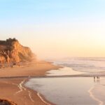 Half Moon Bay from above shows the coastal town nestled between the ocean and green hills, showcasing its scenic location.