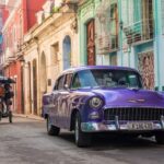 A vibrant street in Havana with classic cars and colorful buildings.
