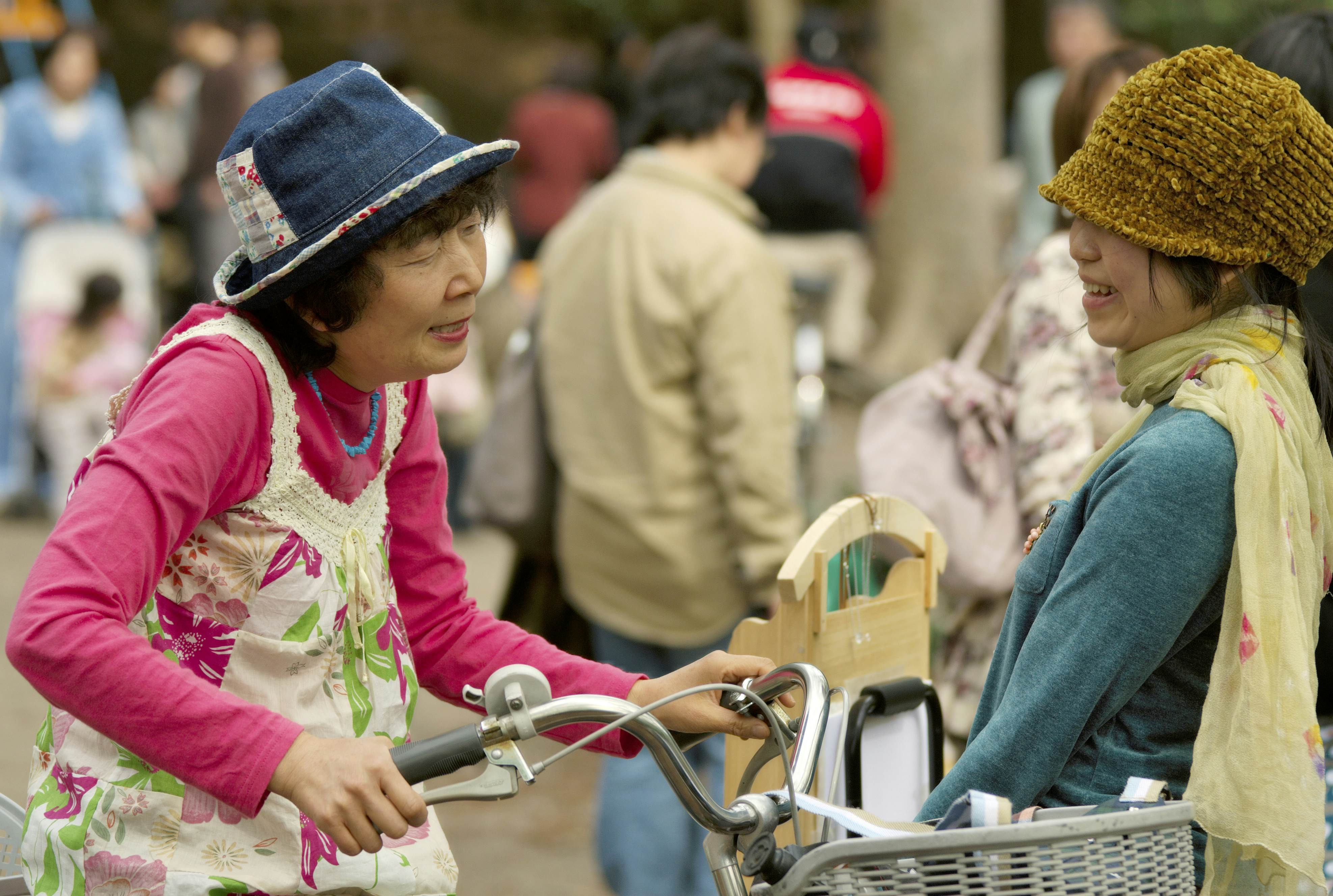 Two women talking on a street in Japan. The image highlights the importance of communication and interaction with locals.
