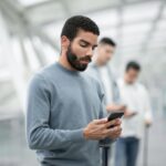 Man on probation using a phone in an airport