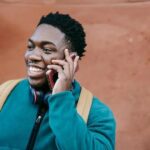 Person talking on a cell phone on the street, emphasizing the importance of staying connected for emergencies.