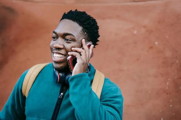 Person talking on a cell phone on the street, emphasizing the importance of staying connected for emergencies.