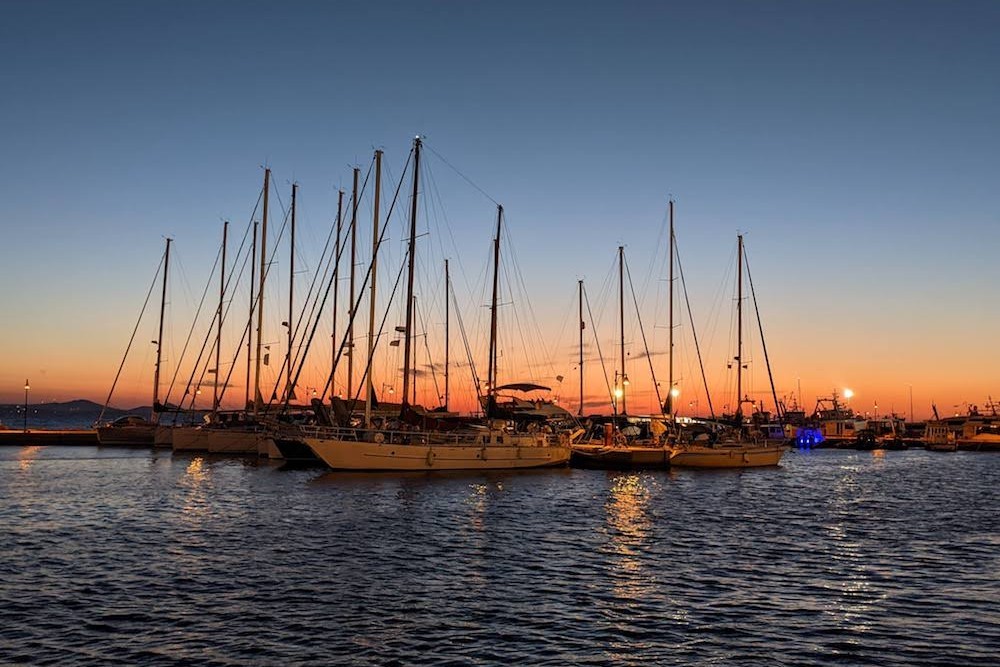 Sunset over sailboats in Naxos Town Greece. The island of Naxos offers great views and activities.