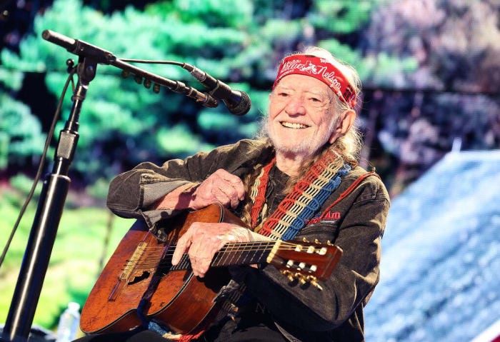 Willie Nelson plays On the Road Again at a concert