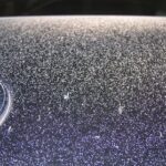 Overspray on a car, illustrating potential damage
