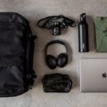 Pakt backpack with items for travel, including a laptop, camera, and headphones