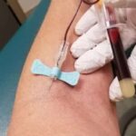 Phlebotomist drawing blood from patient
