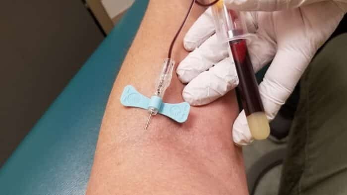 Phlebotomist drawing blood from patient