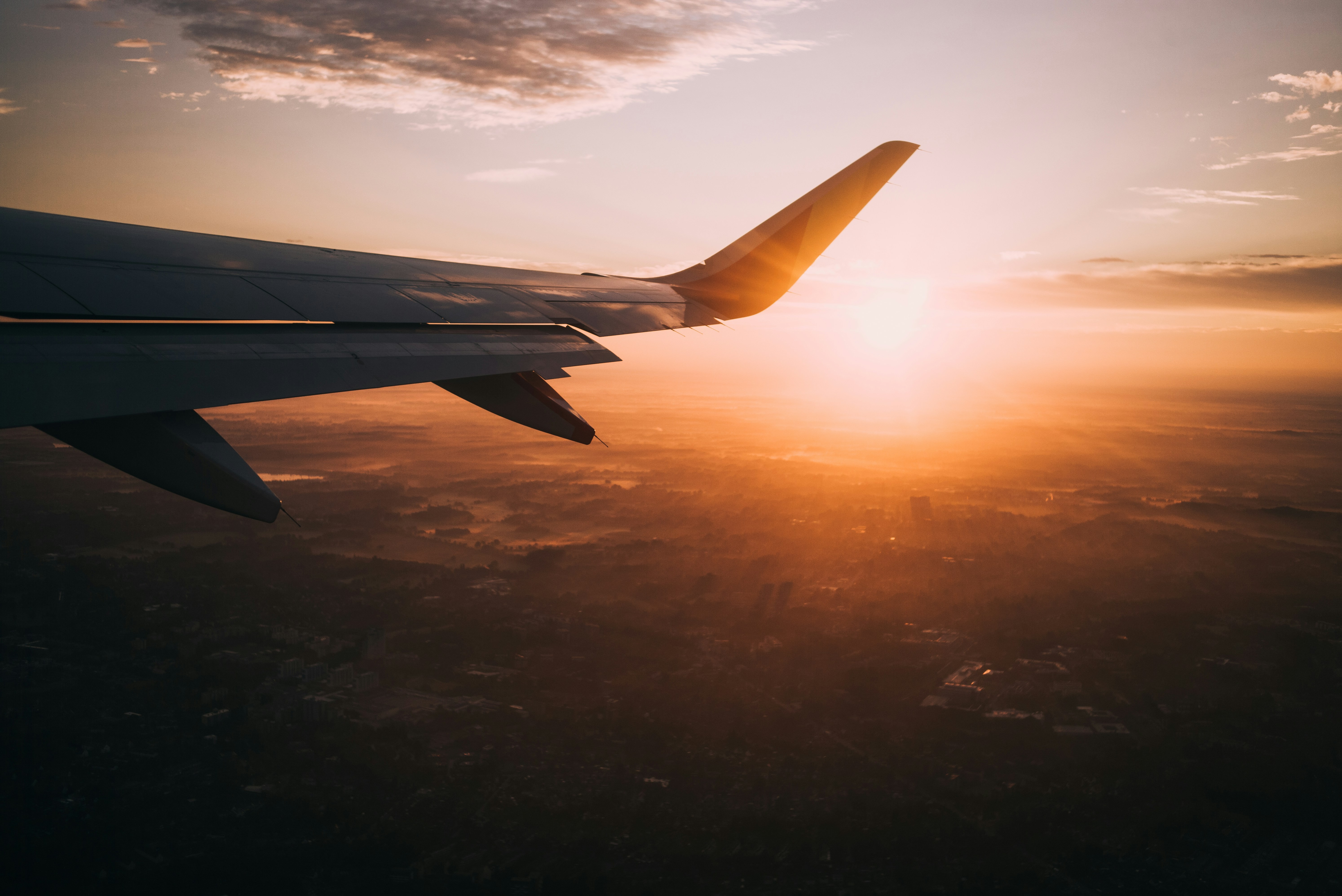 Sunset. A view of an airplane in the sky during golden hour.