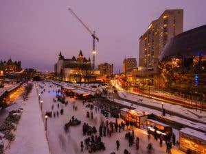 Rideau Canal in Ottawa, Ontario, showcasing the frozen canal transformed into the world's largest natural skating rink, filled with skaters enjoying the winter activity.