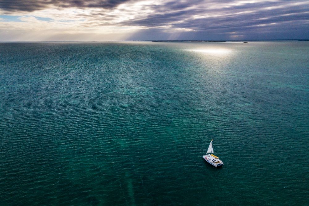 Aerial shot of Belize ocean with sailboat