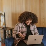 A woman in casualwear works on a laptop in a café, showcasing the flexibility of remote work