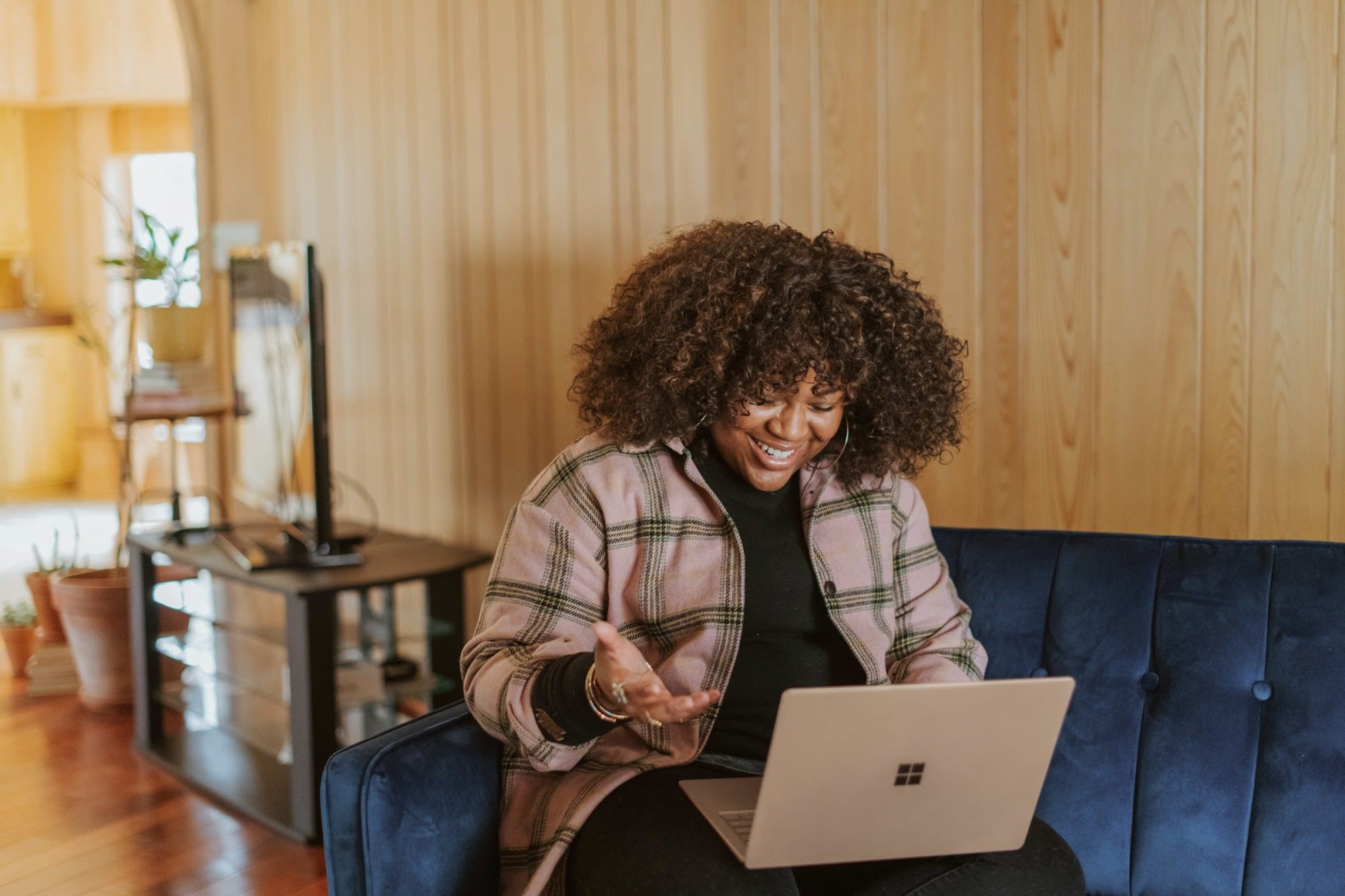 A woman in casualwear works on a laptop in a café, showcasing the flexibility of remote work