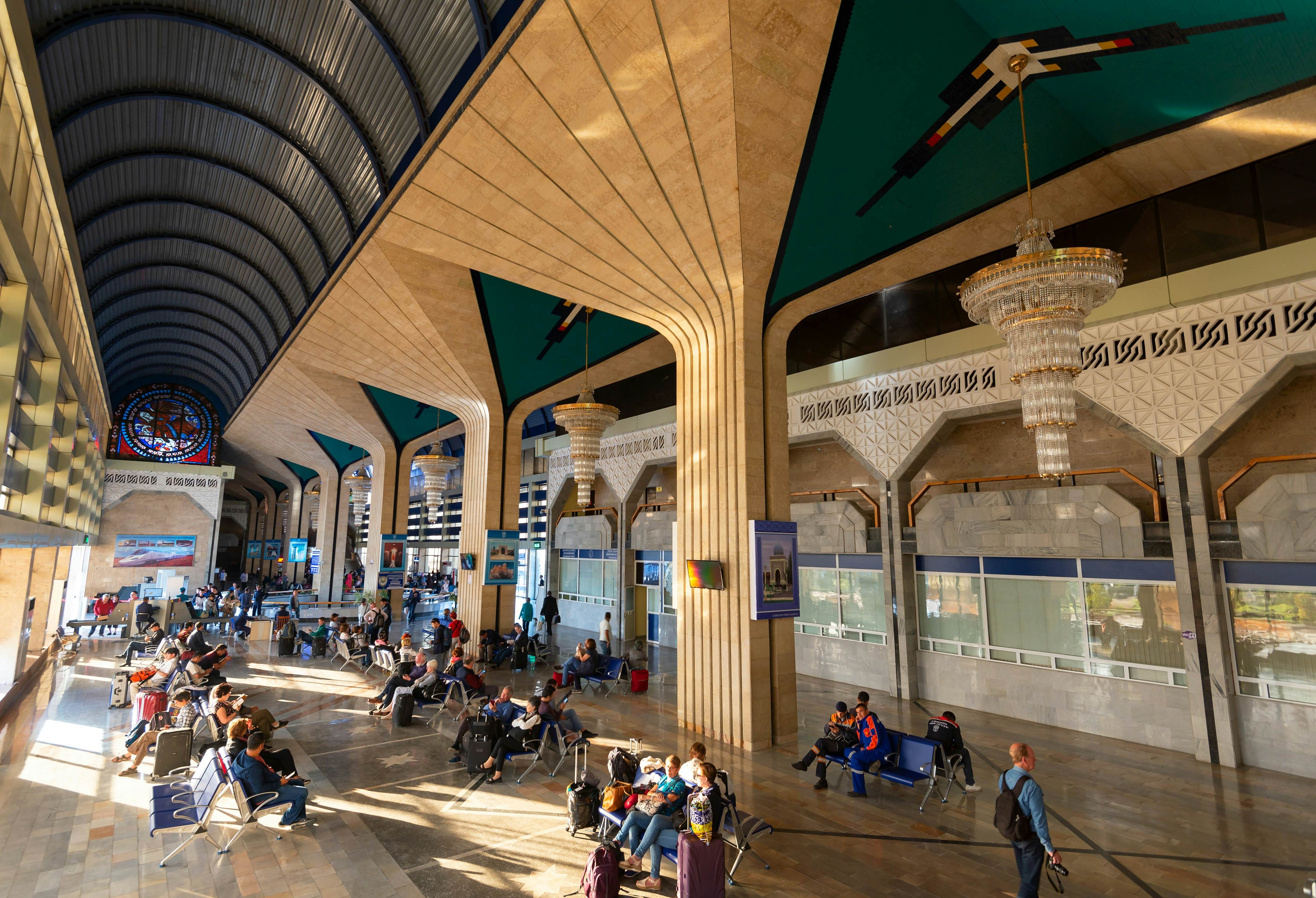 Passengers waiting for the trains to Tashkent and Bukhara surrounded by beautiful stained glass, chandeliers and architecture