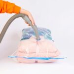 Woman packing vacuum sealed bags into a suitcase