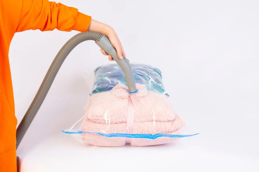 Woman packing vacuum sealed bags into a suitcase