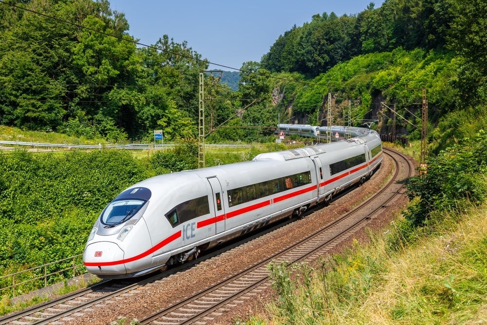 A DB ICE 3 train smoothly navigates a bend on the high-speed railway, illustrating its engineering prowess