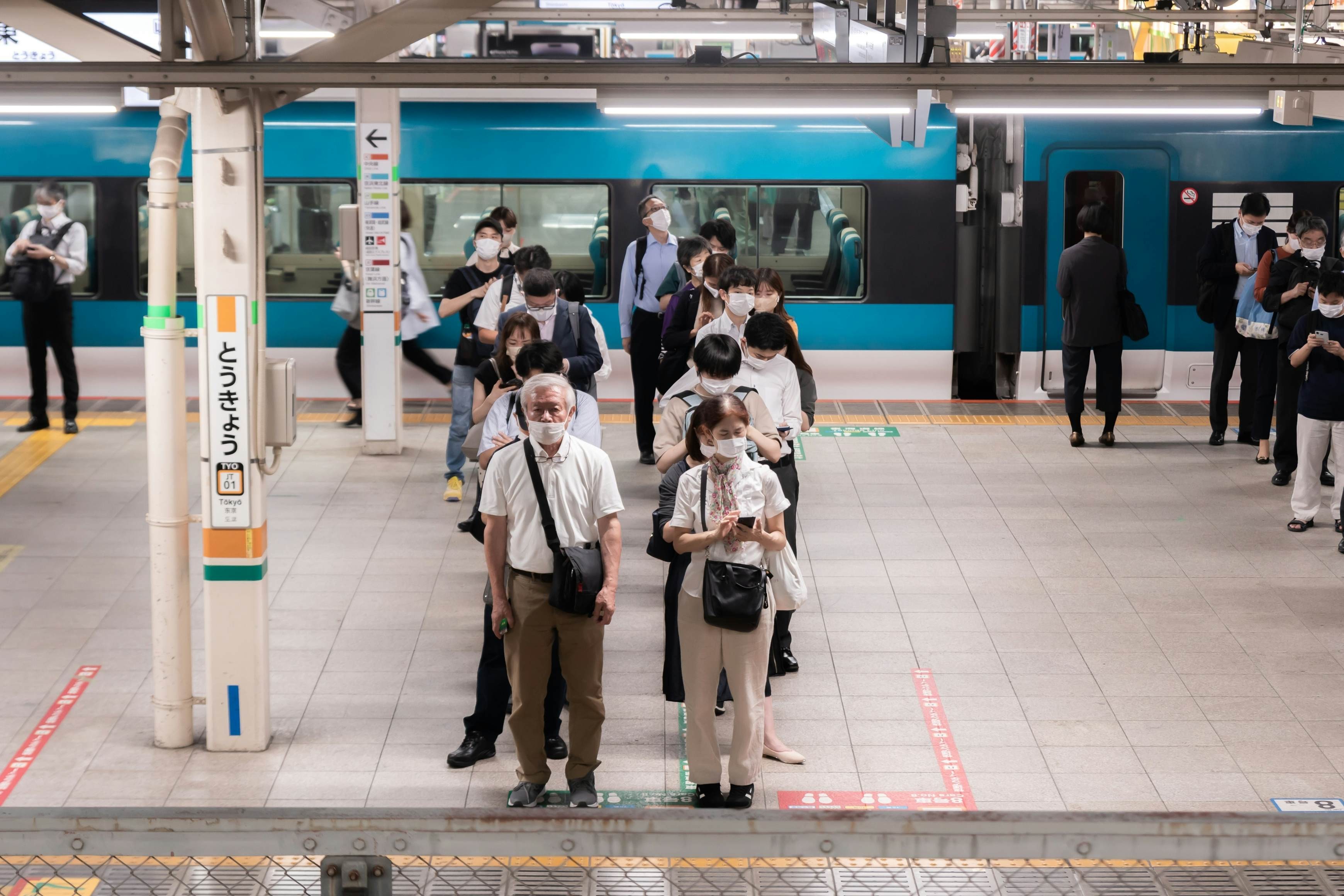 Commuters queueing at Tokyo Station. The image illustrates the importance of queueing in Japanese culture.