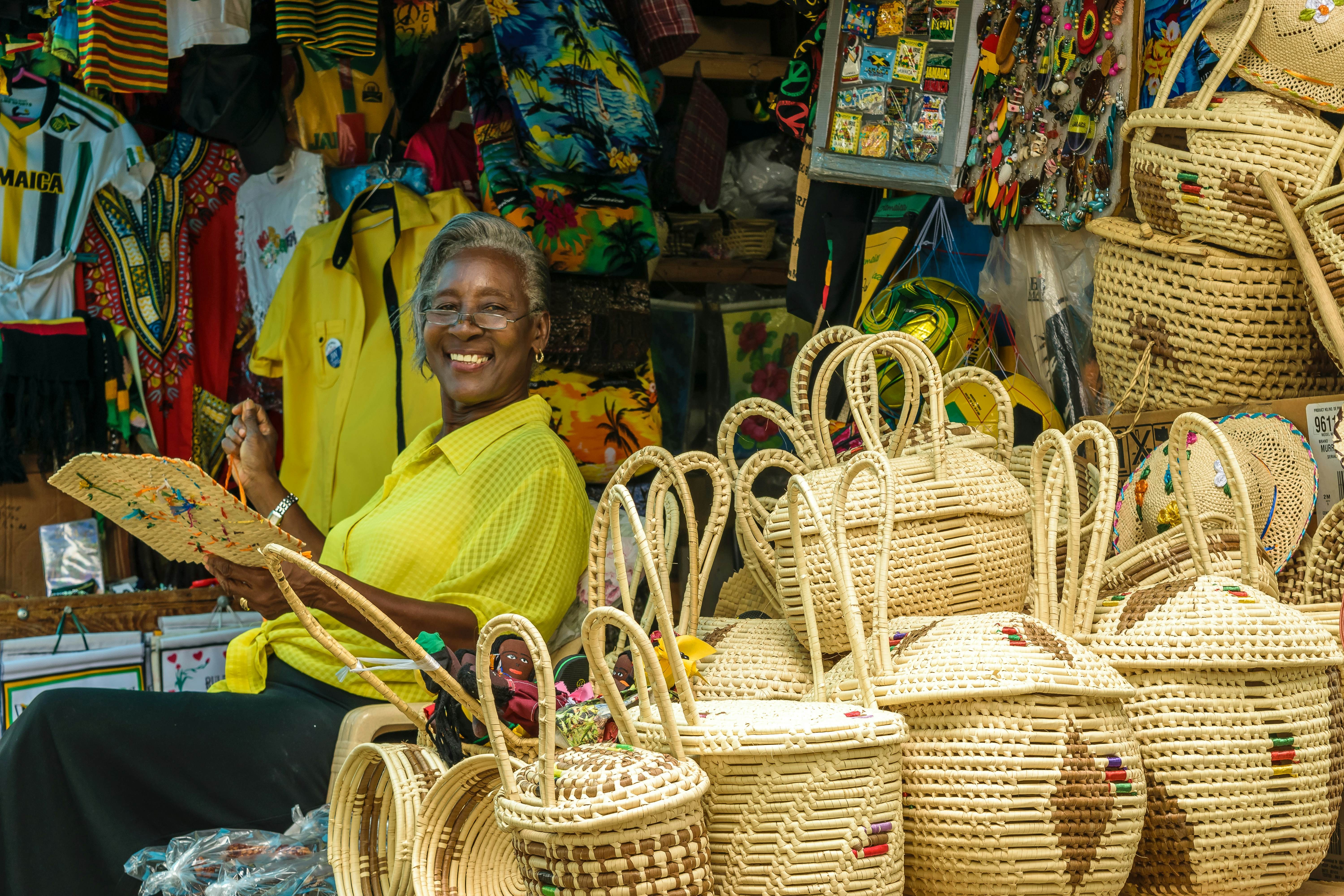 A vendor smiles while weaving baskets in Montego Bay