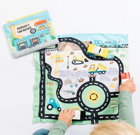 Kids playing with toy cars on a play mat