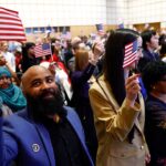 Family waving American flags at a naturalization ceremony