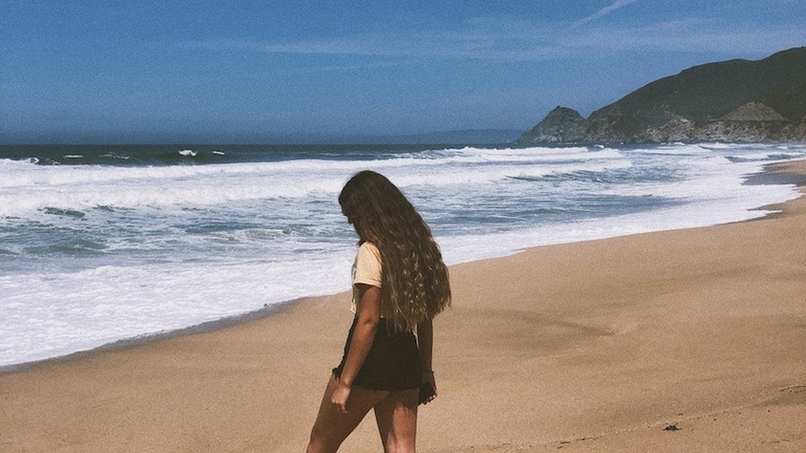 A woman enjoying a solo walk on a San Francisco beach