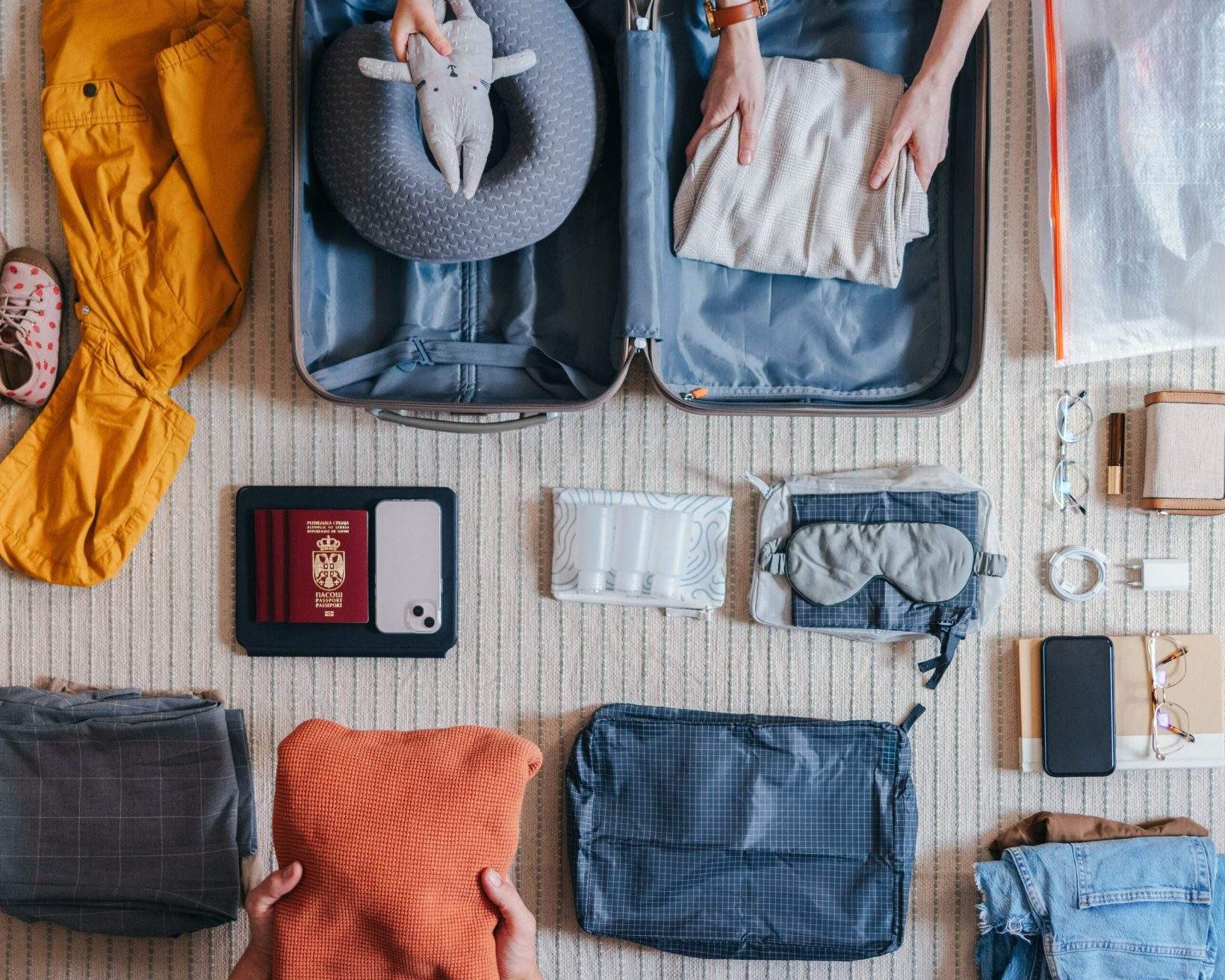Family getting ready for a trip and packing items in a suitcase.