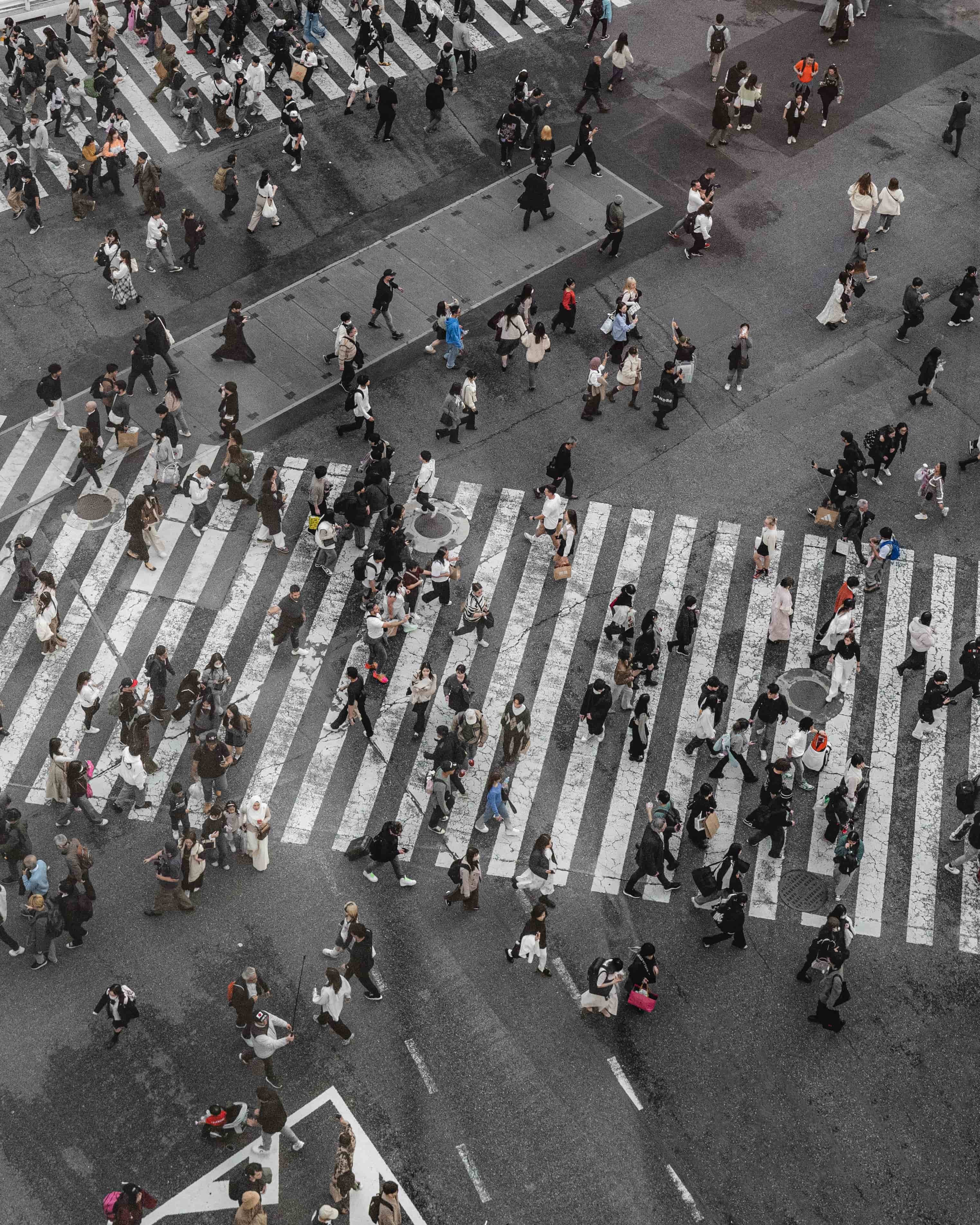 aerial view of people crossing a street in Tokyo, emphasizing the urban lifestyle and connectivity required for remote work