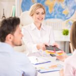 Female travel agent happily assists clients with their travel plans
