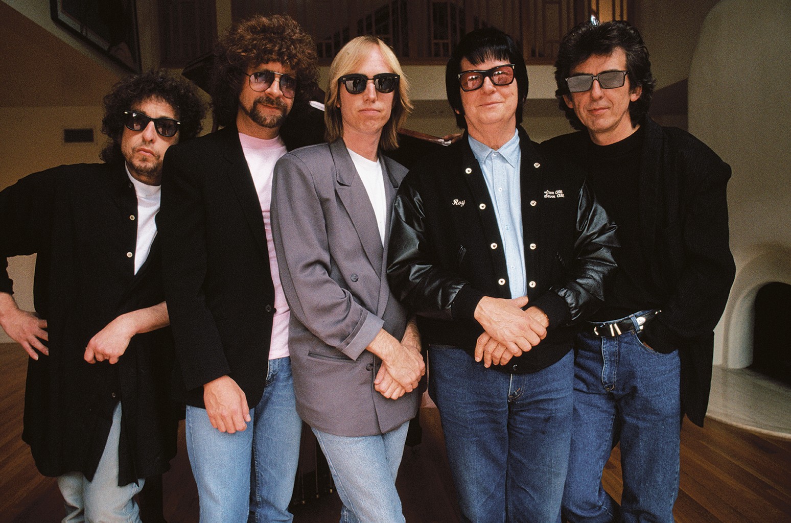 Traveling Wilburys Vol. 1 album cover featuring the band members in a group photo, showcasing their collaborative spirit