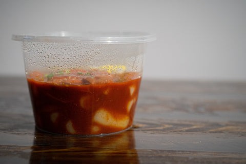 Tteokbokki or Korean rice cake in a takeout food container