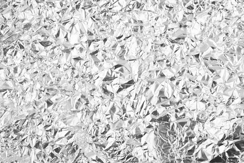 Close-up of aluminum foil being wrapped around food