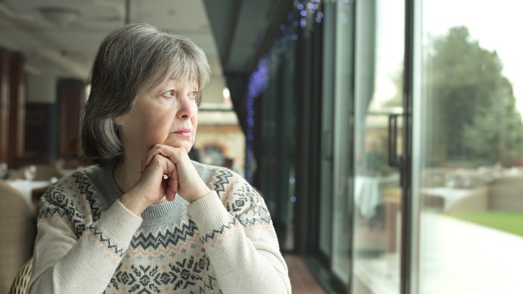 Woman gazing out a window, representing the myth of loneliness in solo travel.